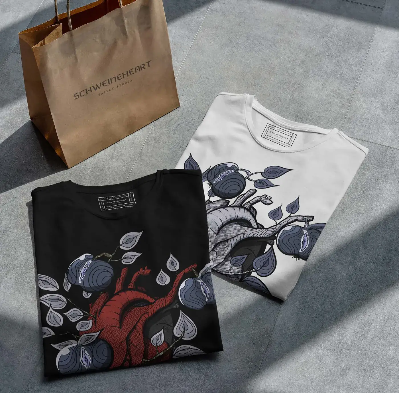 Schweineheart t-shirts with the heart illustration next to a paper shopping bag